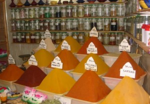 Piles of colorful yellow and orange spices in a Moroccan shop.