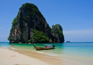 Large rock off the coast of Phra Nang Beach, Thailand, surrounded by deep blue skies and sea.