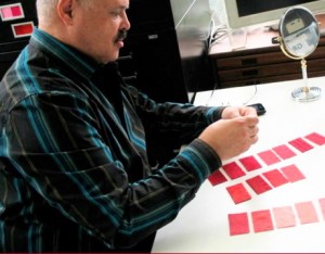 Personal Style Counselor John Kitchener holds up pink Munsell color swatches