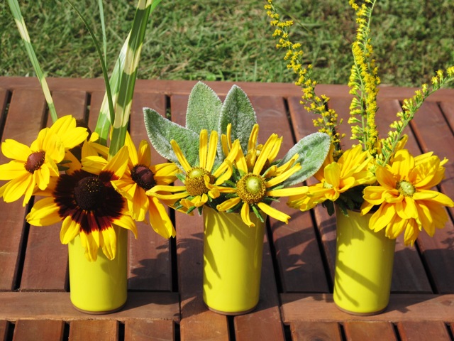 Bring yellow black-eyed Susan's and foliage in bright yellow vases