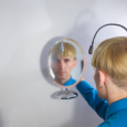 Neil Harbisson, a color blind cyborg who hears colors, viewing himself in a mirror.
