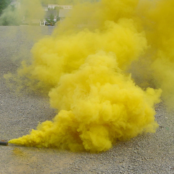 A plume of yellow colored smoke coming off the pavement