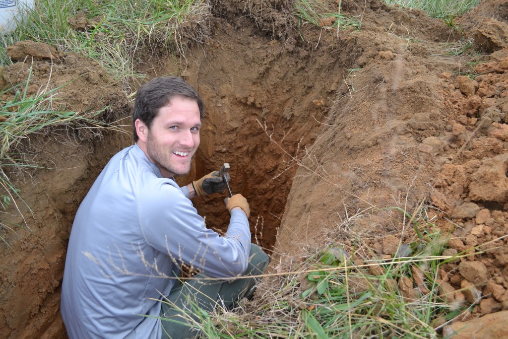 Ernest "Bubba" Beasley, MS, CPG - Geologist, examining soil in a backhoe pit.