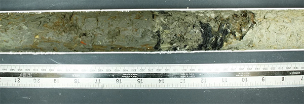 A core sample with a layer rich in charred wood fragments