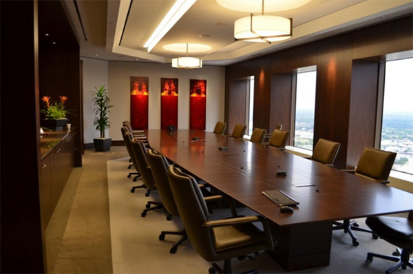 Chrysalids, a red triptych by Leanne Venier hanging on the wall of a conference room