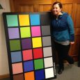 Laura Weeks, lab technician at Munsell stands next to a full size ColorChecker chart