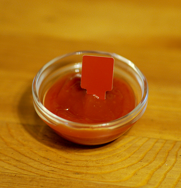 A glass jar filled with ketchup showing the Munsell color notation