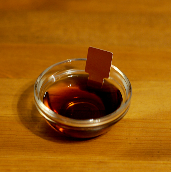 A glass jar filled with malt vinegar showing Munsell color notation