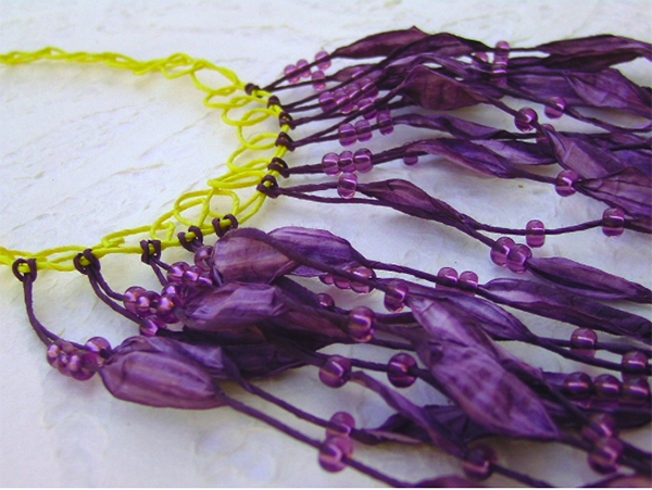 A necklace in purple and yellow made from Czech beads and paper yarn