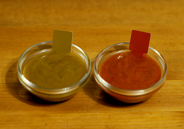 Two glass jars one with red and one with green curry sauce showing the Munsell color notation for each