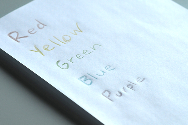 A sheet of paper with the primary colors written down with crayons