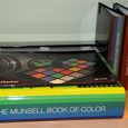A stack of Munsell color books and charts in storage