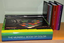 A stack of Munsell color books and charts in storage